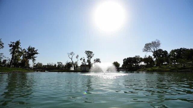 Boats with tourists on the city lake float around the fountains. Sunny summer day