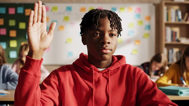 Student raises hand in bright classroom engaged in lesson, peers engaged in learning activities. Clean classroom setting with colorful sticky notes on board