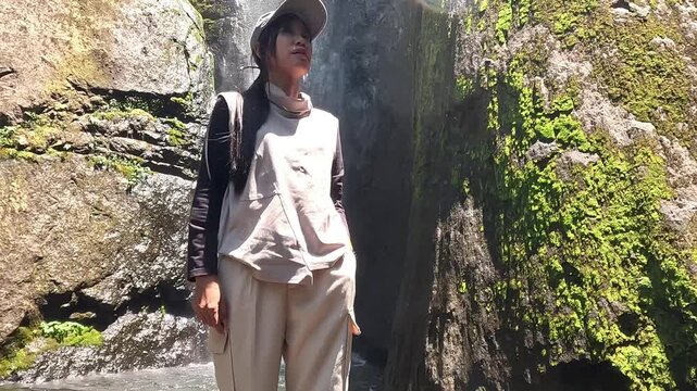 Asian woman vacation at Dolo waterfall. One of beautiful waterfall in East Java, Indonesia.