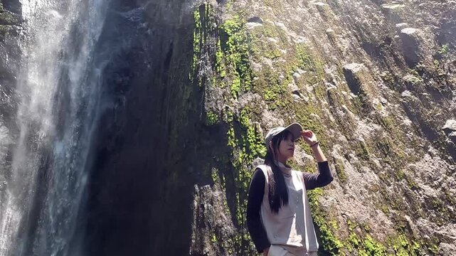 Asian woman vacation at Dolo waterfall. One of beautiful waterfall in East Java, Indonesia.