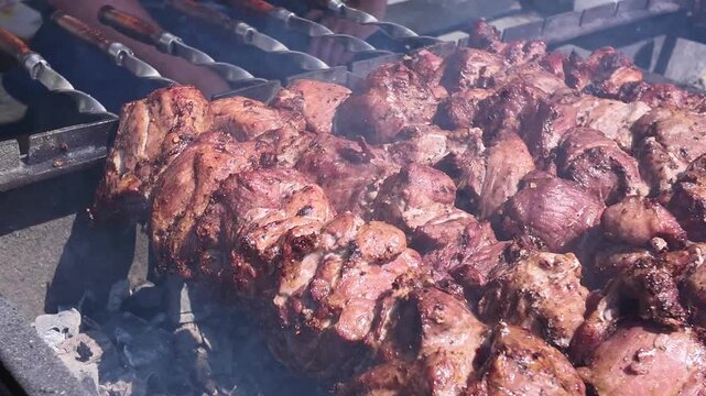 Pieces of juicy meat threaded onto skewers are baked on the grill, street food, background