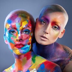 Fototapeta premium Portrait, people and makeup with face paint in studio for beauty, art deco and aesthetic makeover. Creative, women and abstract with bold cosmetics for glamour, festival identity and gray background