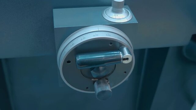 The lathe flywheel rotates in different directions without the operator's intervention, indicating that it is operating according to an automatic program. Closeup. Shot in motion 