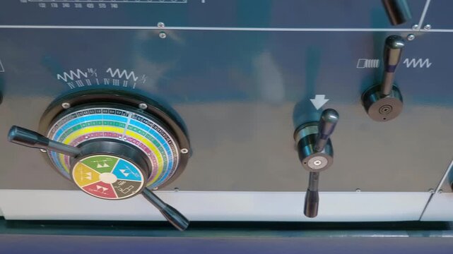 Lathe control levers on the front panel for mechanical switching of equipment operating options. Closeup. Shot in motion