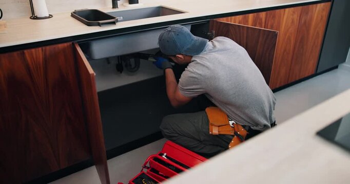 Fixing, pipe and man with tools in kitchen, drainage system maintenance and plumbing skills in house. Handyman, home repair and sink improvement with equipment, installation and leak prevention