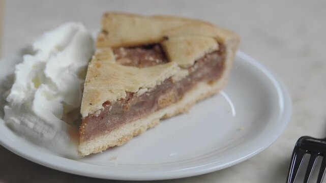 Enjoying a slice of pie with whipped cream on a plate