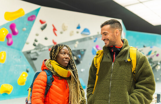 Diverse friends talking at indoor bouldering climbing gym