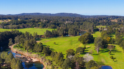 Fototapeta premium Aerial View of a Winding River Through Lush Green Valley
