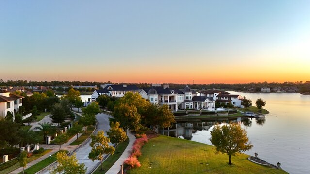 Aerial view of luxury houses in Houston, Woodlands by the lake with dramatic cloudy sky in Texas, United States