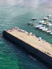 Fototapeta premium Aerial View of a Stone Pier and Moored Boats in Fife