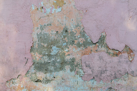 Grunge dirty pink orange wall. Fragment of old house wall as background. Damaged painted wall.