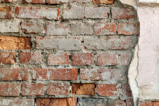 Old dirty brick wall of damaged  house. Grunge brown brick texture.