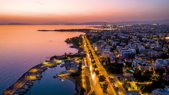 Aerial hyperlapse view of the southern coast of Athens, Greece, with Voula district, boat marinas and street traffic during evening time