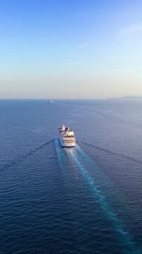 High aerial view of a cruise ship sailing over blue ocean into the sunset with copy space as a concept for travel and vacation