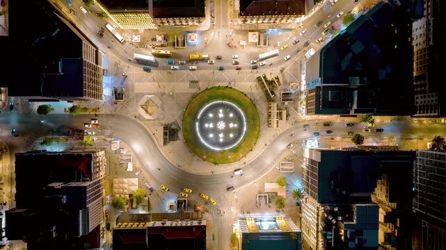 Aerial overhed timelapse view of the illuminated Omonia Square in central Athens, Greece, during night time with street traffic