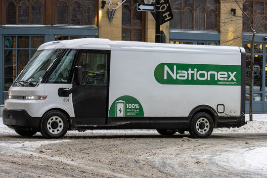 Canada, Montreal, 24 December 2025 : Nationex electric delivery van driving through snowy urban street