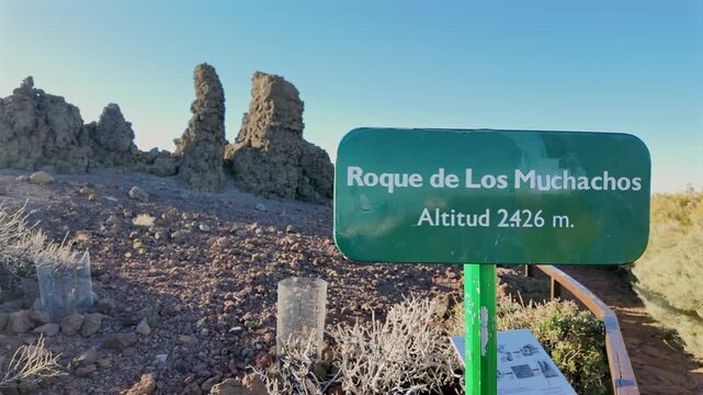 Sign showing the altitude of Roque de Los Muchachos, the highest point on the island of La Palma, with rocky volcanic landscape in the background