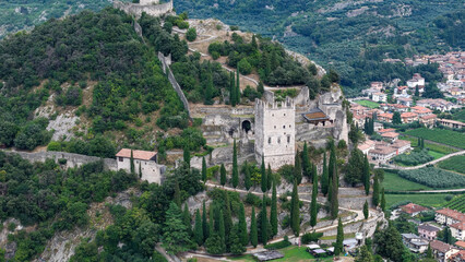 Obraz premium Exploring the historic cliffs of an ancient castle nestled in lush greenery under a clear blue sky