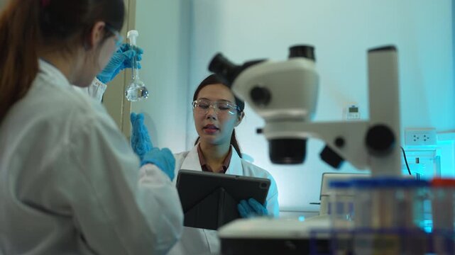 Team of biochemical research scientists using microscopes for vaccine development in a pharmaceutical laboratory, medical research and healthcare innovation.