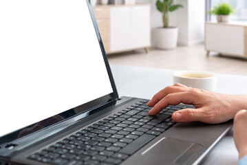 Fototapeta premium Closeup of hands typing on laptop with isolated screen in bright office environment, suitable for software mockups, business presentations and digital branding