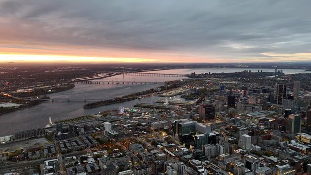 Vibrant sunrise over Montreal skyline with St Lawrence River and La Grande Roue reflecting colorful evening sky. g.