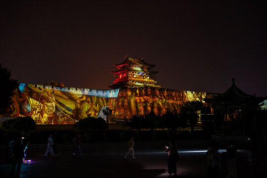 Ancient Chinese fortress illuminated with vibrant light projections at night