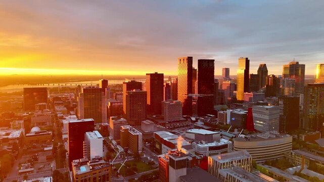Vibrant sunrise over Montreal skyline with St Lawrence River and La Grande Roue reflecting colorful evening sky. g.