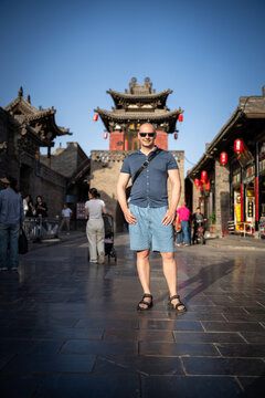 Man posing in front of ancient Chinese architecture in Pingyao