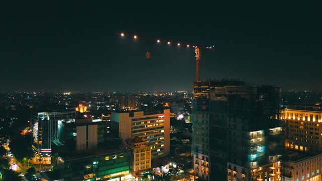 Aerial Night View of Construction Crane and Urban Skyline &ndash; City Development in Southeast Asia
