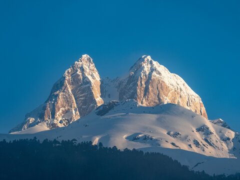 Mount Ushba in Svaneti, Georgia. Snow-capped peaks rise sharply against a clear blue sky