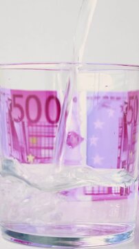Water splash from glass with euro bill background in concept of economic growth