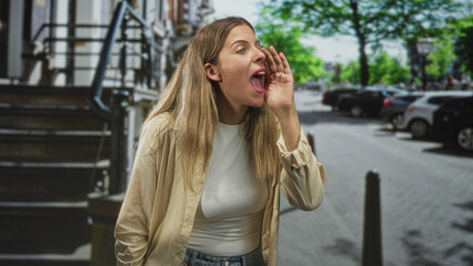Fototapeta premium Woman cupping hands calling out on a city street by stairs and parked cars; excitement social connection.