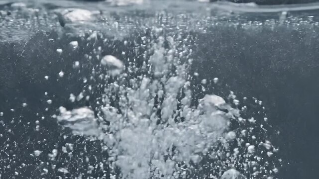 Close up of clear water with rising bubbles and turbulence.
