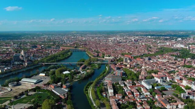 4K aerial view of Toulouse with Garonne river, &Icirc;le du Ramier island, La Grave hospital dome and characteristic pink terracotta rooftops earning Toulouse the name La Ville Rose.