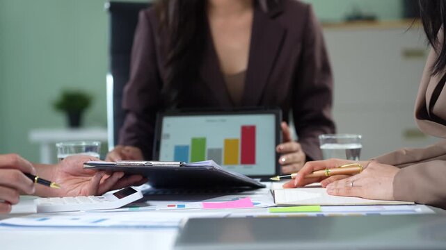 Business consultants discuss tax, merger strategy and restructuring in modern office.
