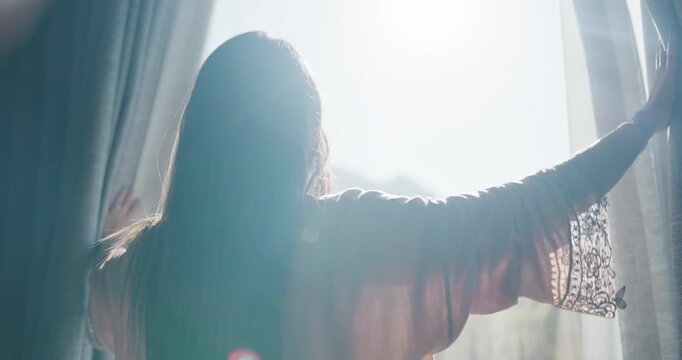 Woman, light and open with curtains in bedroom for morning, stretching or new day in home. Back view, female person or awake with fabric, flare or window for outdoor sunlight, rise and shine in house