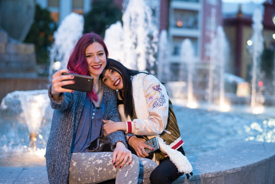 Women in the city taking fountain selfie