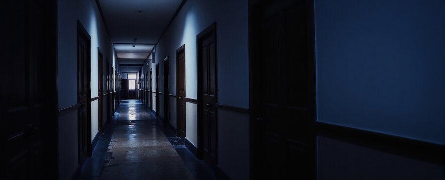 Dark, narrow hallway with many closed doors leads towards light. Eerie atmosphere, suspense, mystery. Creepy interior, abandoned building, school, hospital setting. Long corridor.