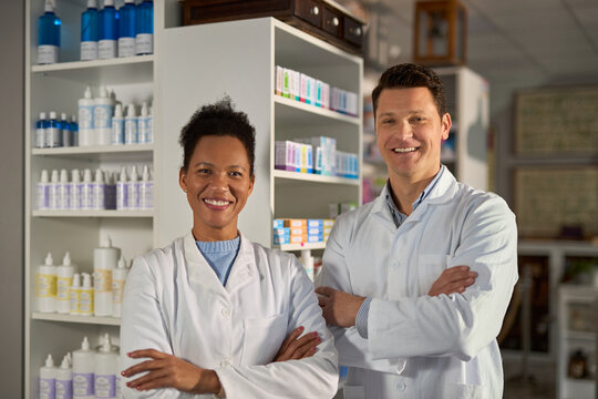 Portrait of happy diverse pharmacists standing in apothecary  and looking at camera.