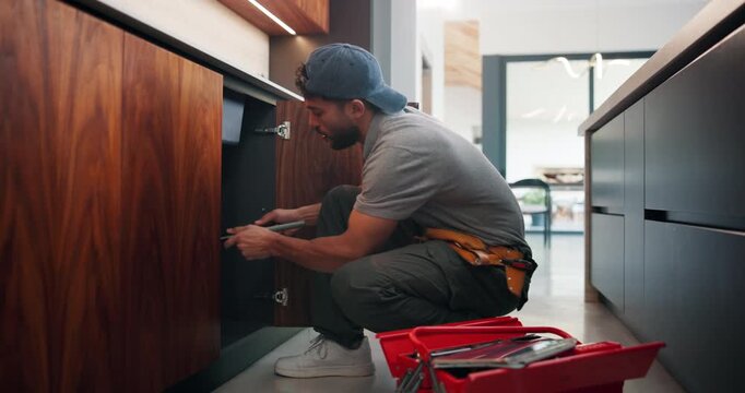Sink, repair and man with tools in kitchen, drainage system maintenance and plumbing skills in house. Serious, plumber and pipe improvement with equipment, installation and leak prevention in home