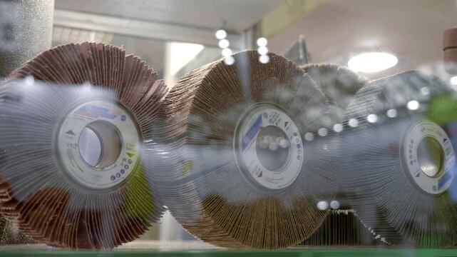 In a glass display case are new universal radial petal wheels, designed for grinding work. Closeup. Shot in motion