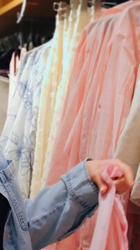 Woman examines dress. Woman observes intricate embroidery on dress. Woman explores delicate lace and embroidery on dress. Woman carefully feels and examines fine lace and embroidery of dress