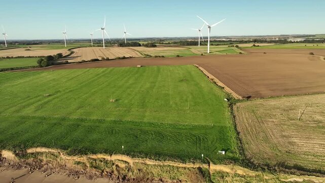 Aerial View of Wind Turbine Farm Over Patchwork Fields in Yorkshire Countryside UK