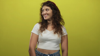 Woman smiling with bare midriff wearing white tshirt and jeans three quarter view in lime green...