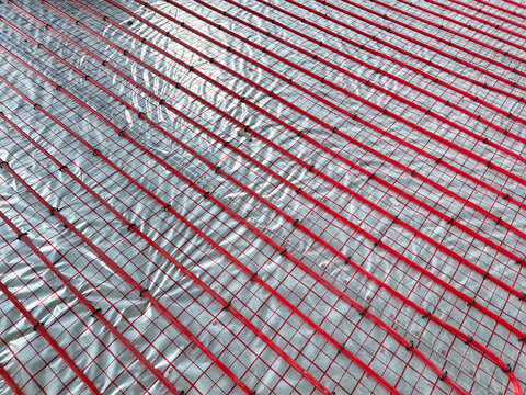 Installation of underfloor heating system in building, above view