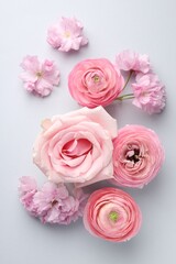 Fototapeta premium Beautiful flowers on light background, flat lay