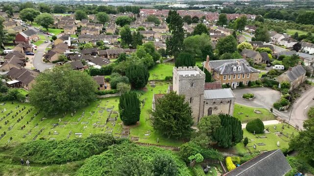 Aerial Orbit Around Historic Stone Church and Cemetery in Barton Seagrave Northamptonshire England