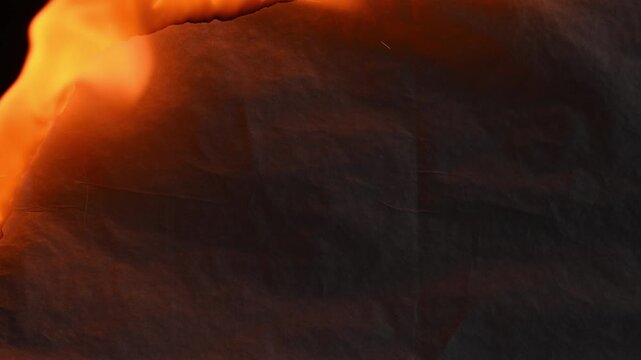 Burning paper sheet on black background fire flames macro close-up