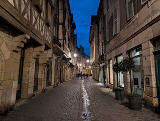 Naklejka premium Street and timber framing houses in historic downtown Dijon at night, France - May 2026