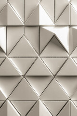 Obraz premium A close-up view of a textured wall composed of interlocking white squares and triangles. vertical frame